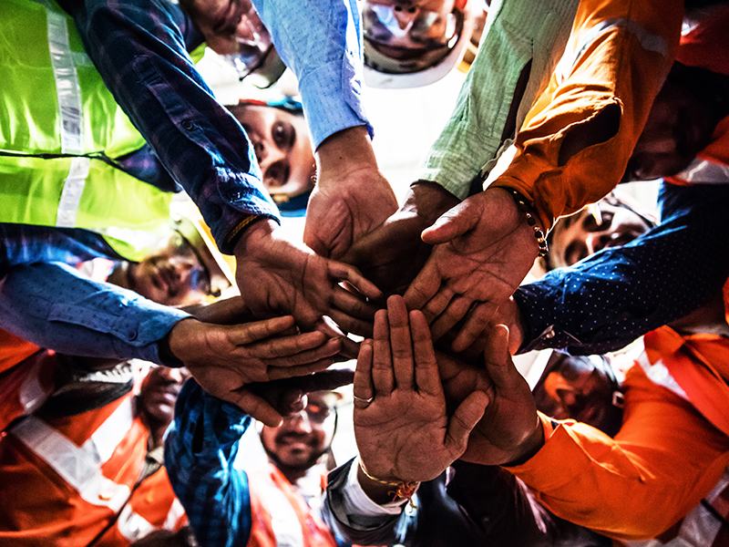 Below angle of team members joining hands