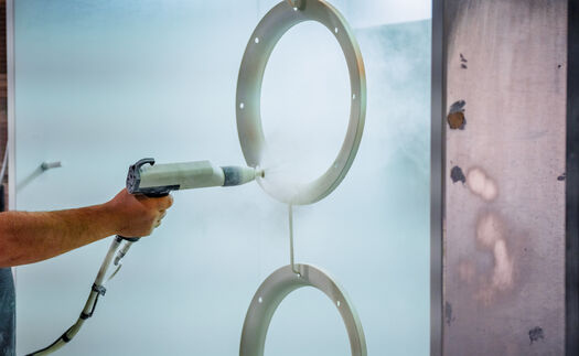 A hand using a polyurethane paint gun.